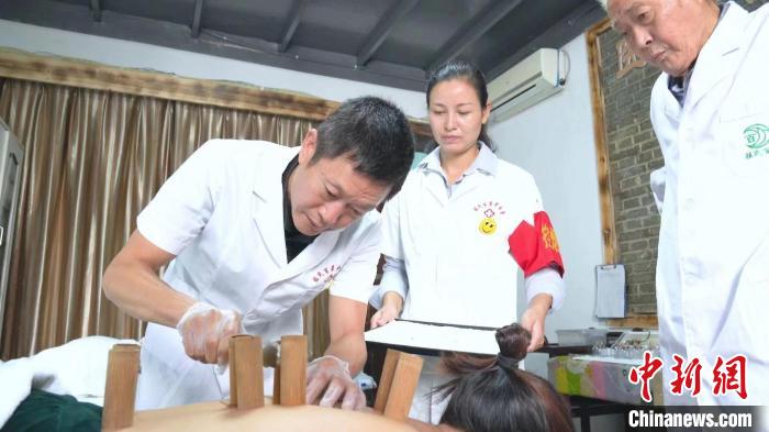 胡玉平在祖氏百草中医馆为患者实施中药刺络竹筒拔罐。　程志强 摄
