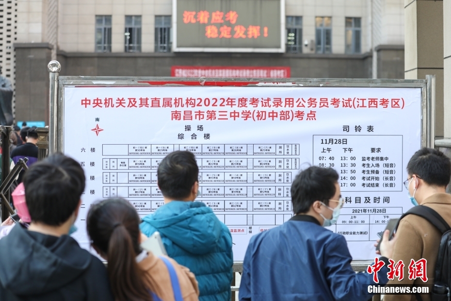11月28日，江西南昌第三中学(初中部)考点，考生们在查看考场安排表。当日，中央机关及其直属机构2022年度考试录用公务员公共科目笔试举行。<a target='_blank' href='/'>中新社</a>记者 刘力鑫 摄